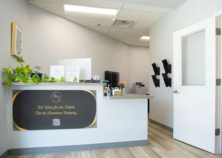 Reception desk with the “We Work for the Patient, Not the Insurance Company” sign at Dickson Physical Therapy