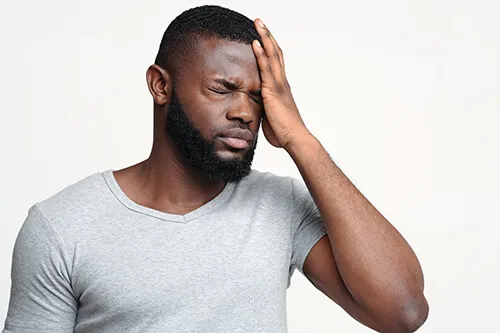 Man holding his head with a headache after a concussion