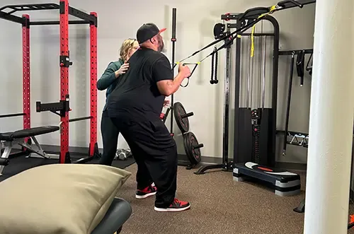 Patient performing a suspension strap exercise with therapist guidance